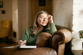Older woman looking out of the window while in stimulant addiction.