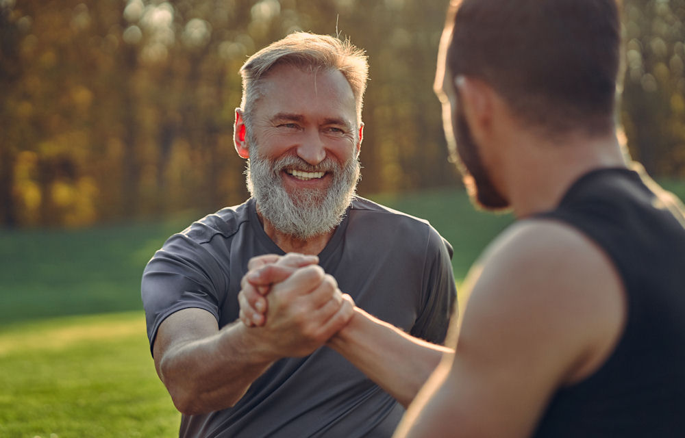 Older man high-fiving man after exercise in inpatient rehab in Florida.