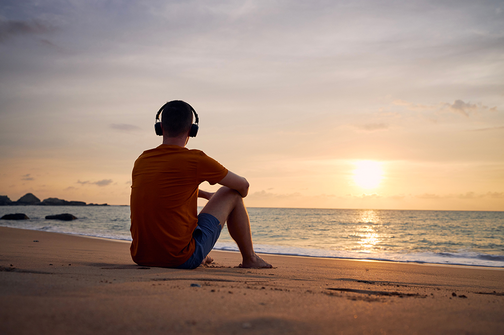 Man sitting peacefully on the beach during inpatient rehab in South Florida.
