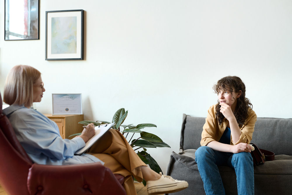 woman speaking with a therapist at an alcohol rehab center