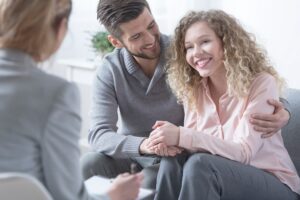 Man hugs woman during couple-focused DBT session.