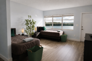 Two-bed client room with large windows overlooking the lake