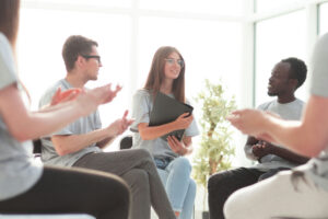 Group members clapping to encourage a peer during IOP group therapy
