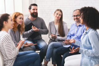 Diverse adults sharing in a supportive group session at one of the leading Florida IOP programs